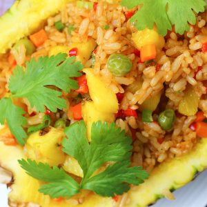 delicious pineapple Thai fried rice in a pineapple bowl and garnished with fresh cilantro