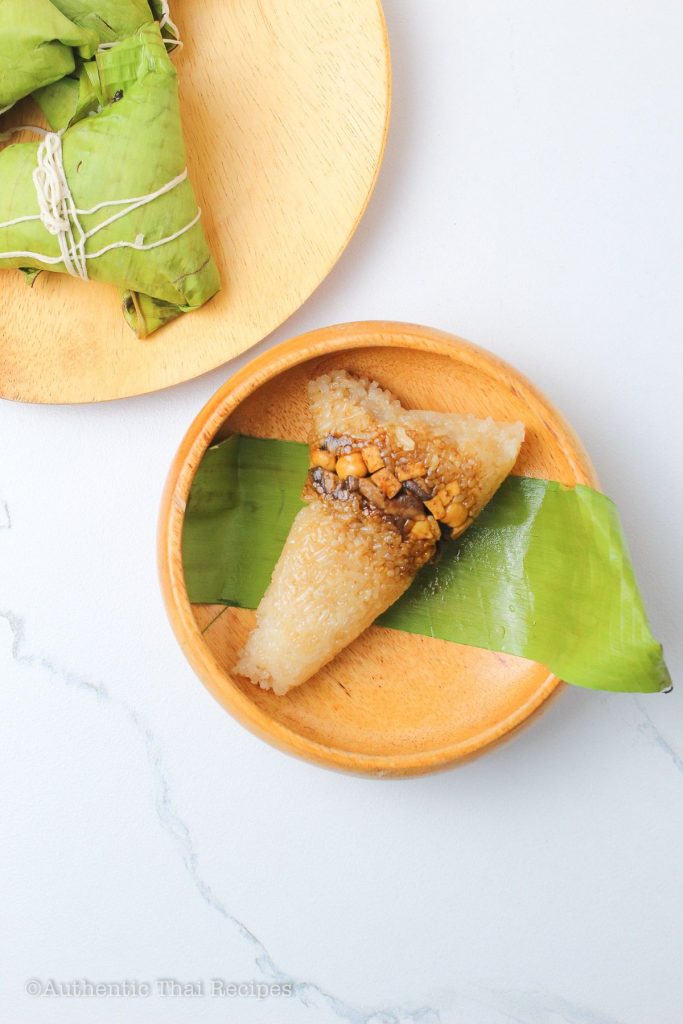 unwrapped sticky rice dumplings on a wooden bowl