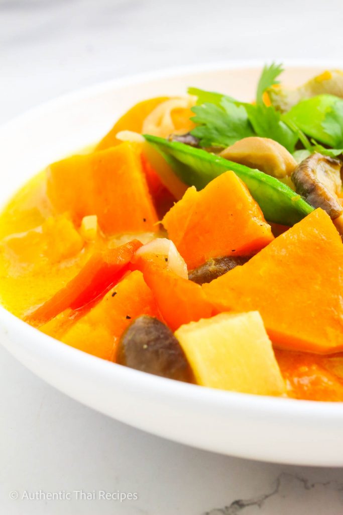 up close shot of green curry soup in a white bowl