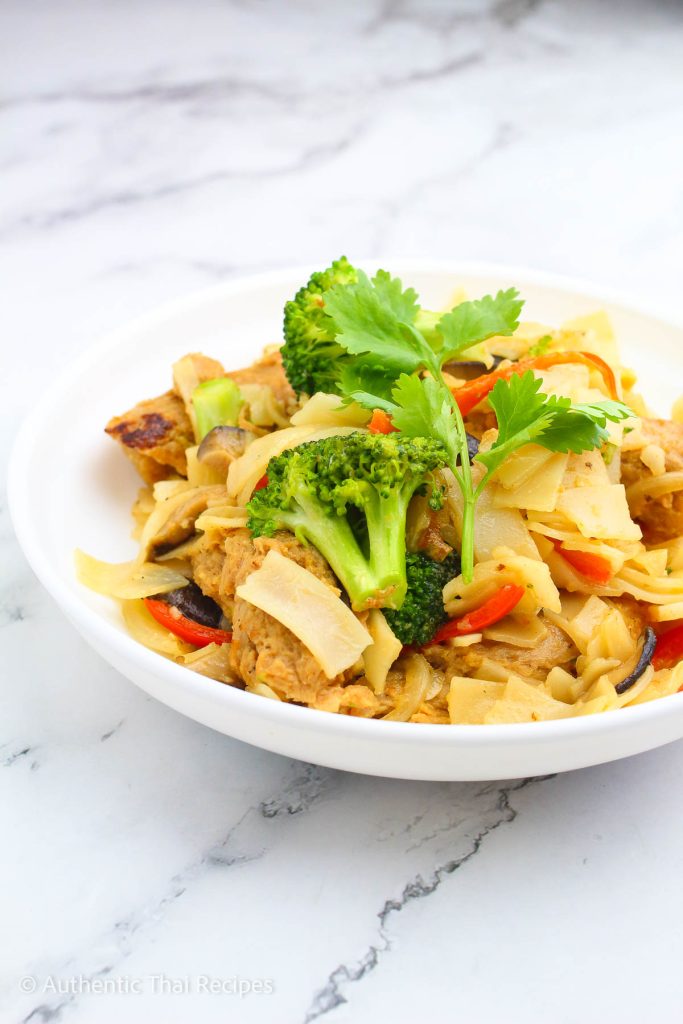 Pad See Ew on a plate topped with parsley leaf