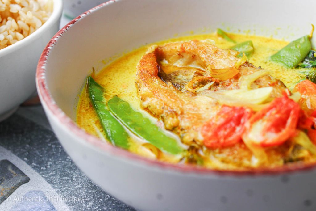 A bowl of fish, vegetables and soup